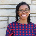 Portrait of Alexandria Mason standing in front of a stone wall