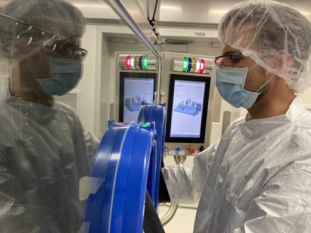 Waisman Biomanufacturing staff member Matt Walch operates the robotic aseptic filling line