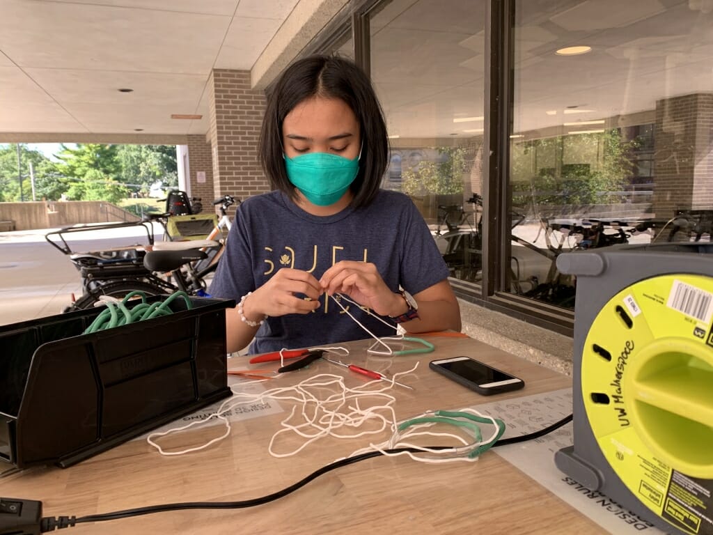 Student sitting at table assembling mask fitter