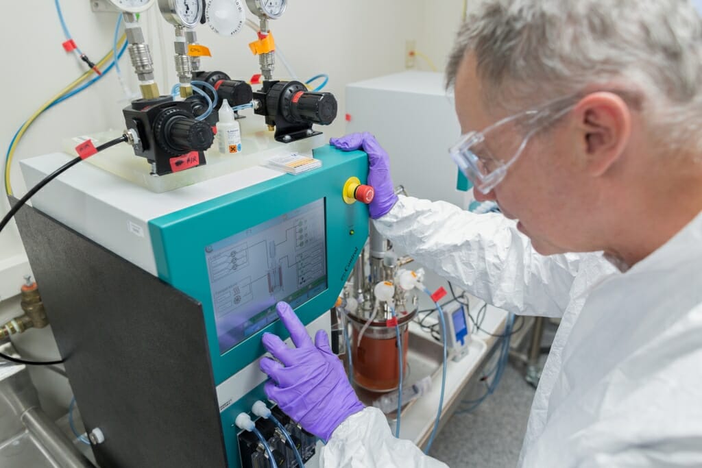 Man in goggles looking at bioreactor