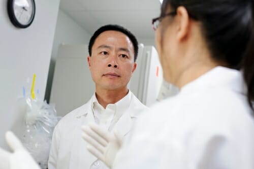 Su-Chun Zhang in his lab listening to a researcher