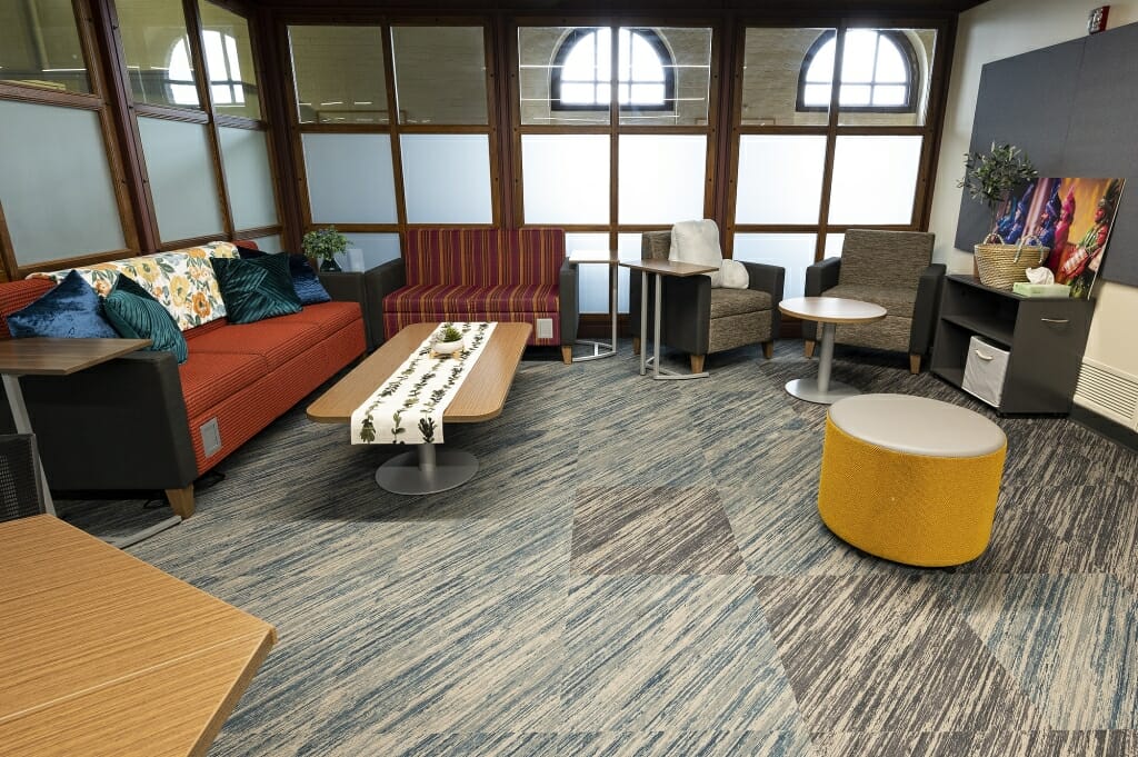 Couche, chairs and tables in a room surrounded by windows