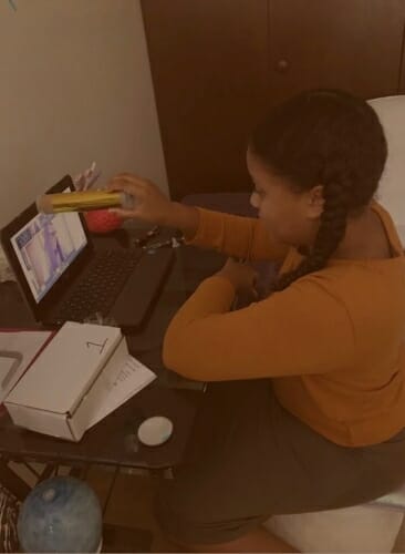 Student sitting at desk looking at laptop screen