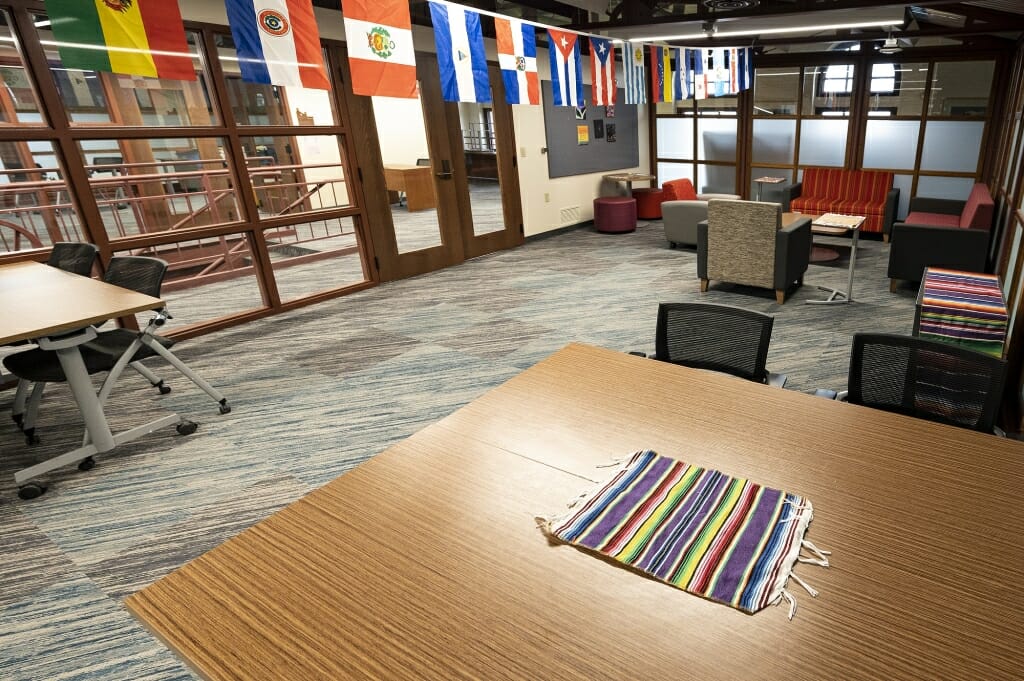 Room with tables, chairs and international flags