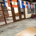 Room with tables, chairs and international flags