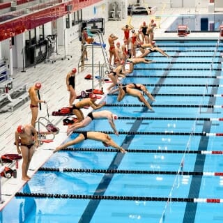 Swimmers lined up along pool edge