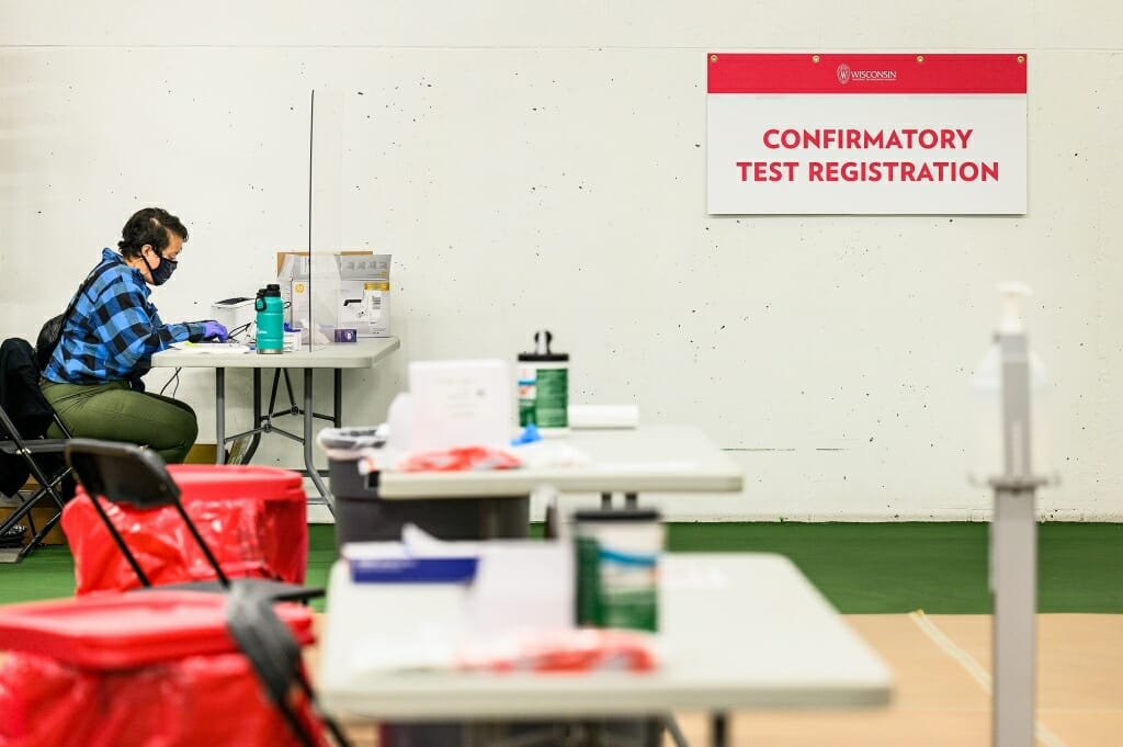 A staff member waits for anyone needing a follow-up PCR test, required to confirm a positive coronavirus result from the rapid BinaxNOW test.