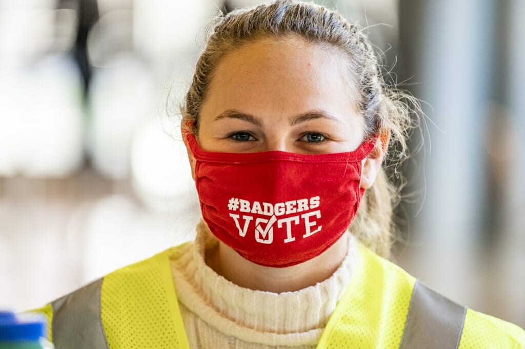 UW student volunteer election worker Elise Goldstein shows off the voting message on her face mask.