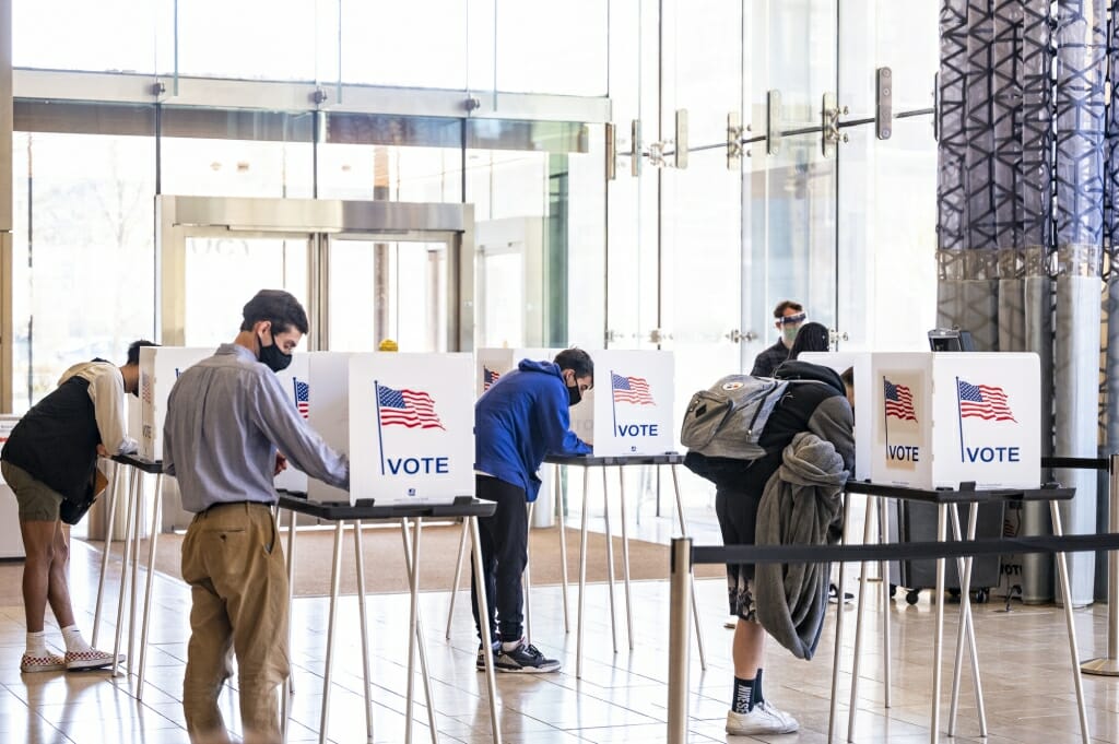 Students cast their ballots at physically distanced voting boxes at the Chazen Museum of Art polling station.