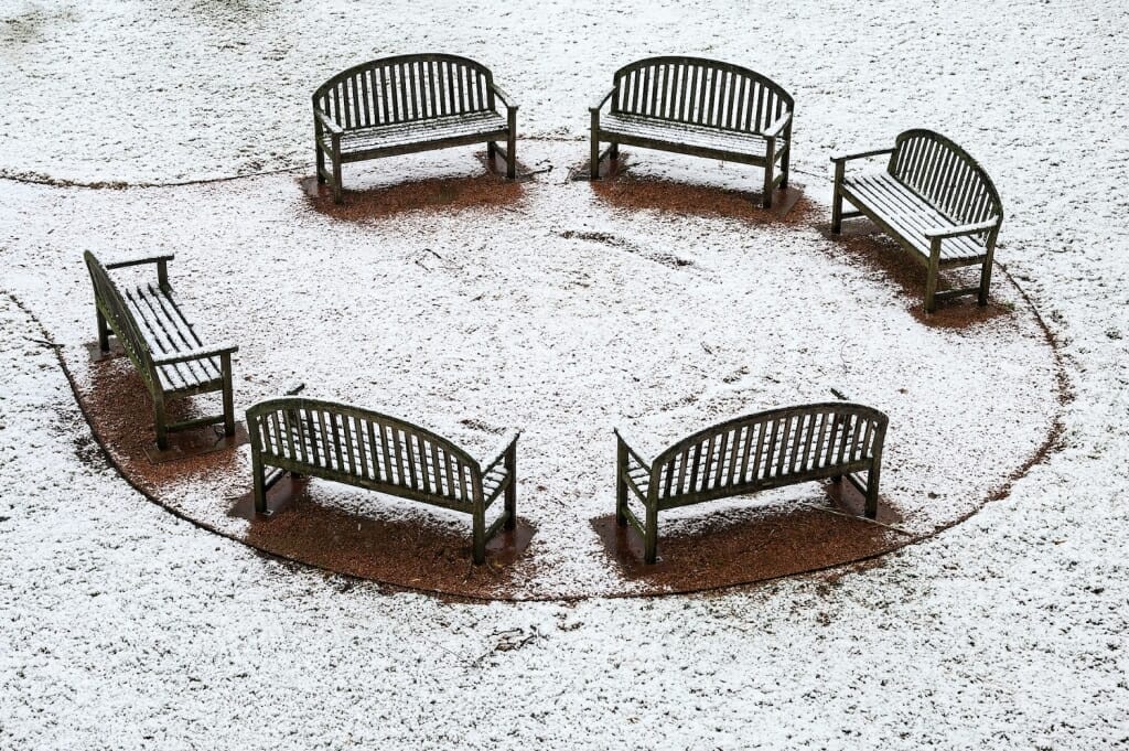 A circle of six empty benches near Vilas Hall are awaiting spring.