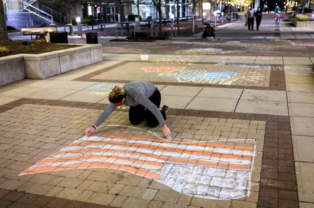 Maloney puts the finishing touches on an American flag, in chalk.
