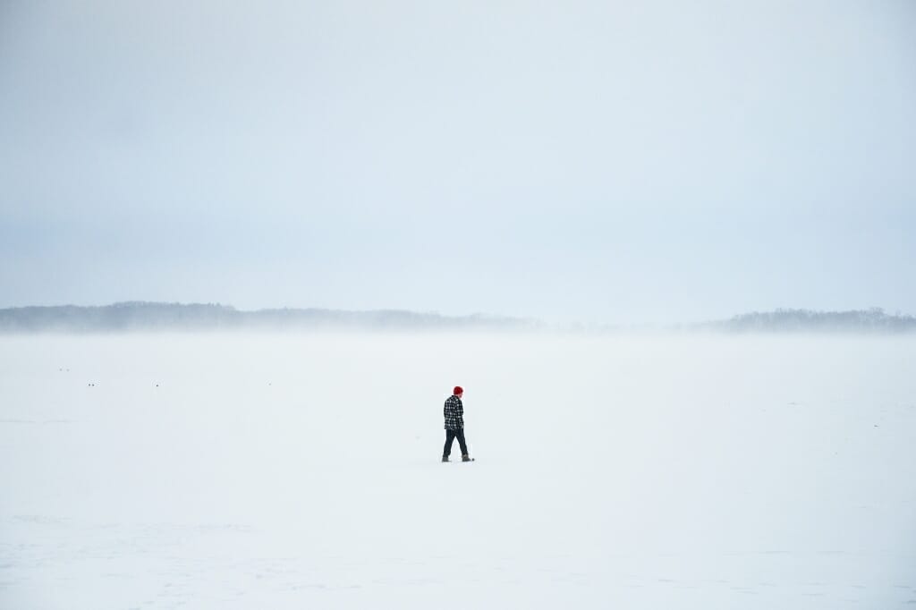 Unidentified person walking on snow-covered lake