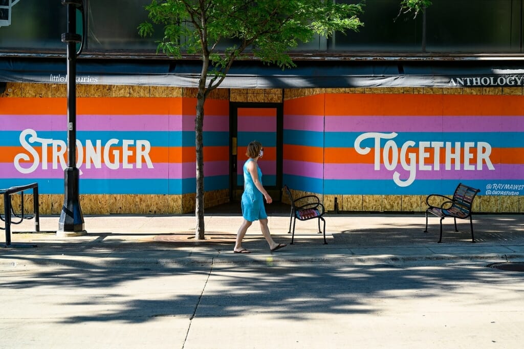 Person walking past painted words 