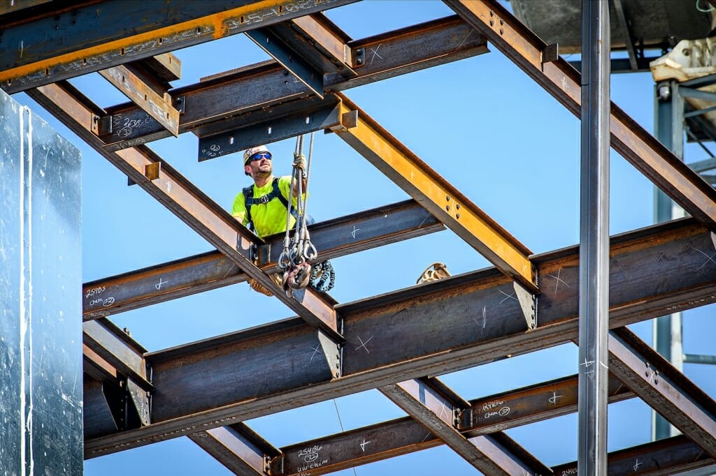 Person working on beams of building under construction