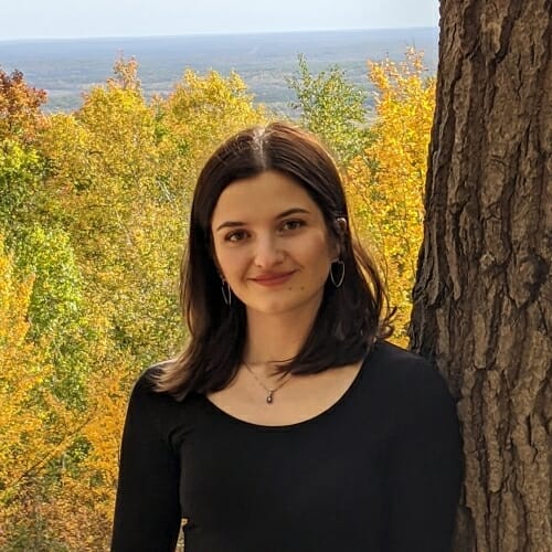 Portrait of Alexis Lipkie leaning on a tree