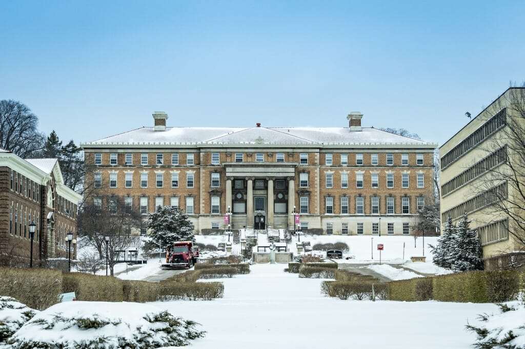 A plow clears snow from Henry Mall in front of Agricultural Hall.