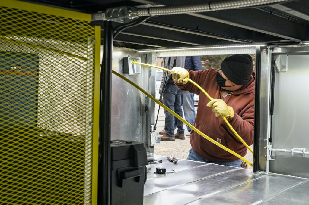 Electricians with the UW Electric Shop install power and data cables for the testing lab.