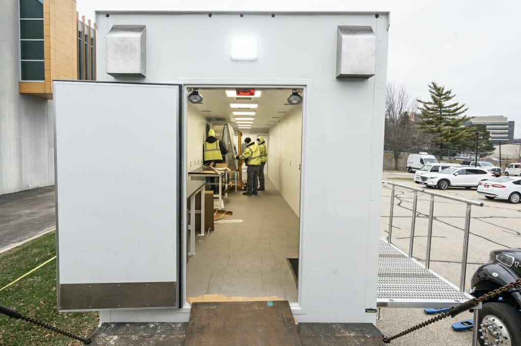 Workers install a lab fume hood on the lab.