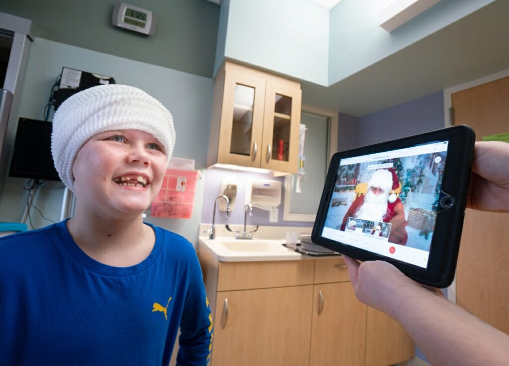 Easton Denor, 8, of Denmark, Wis., laughs along with Santa during their chat.