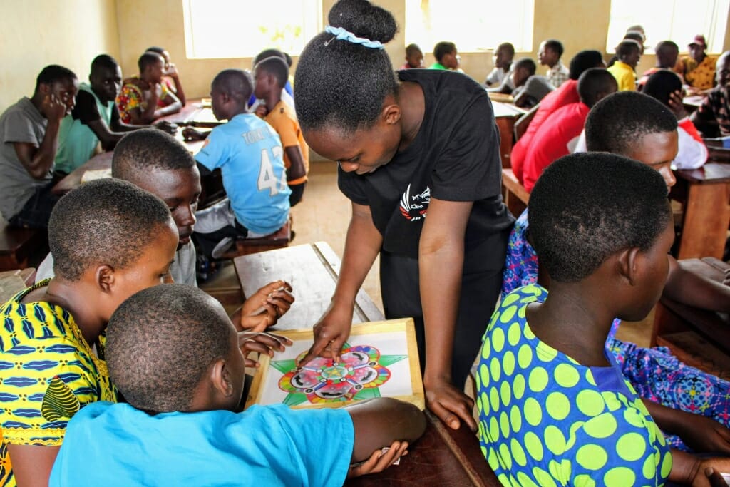 Person pointing to game board while children look