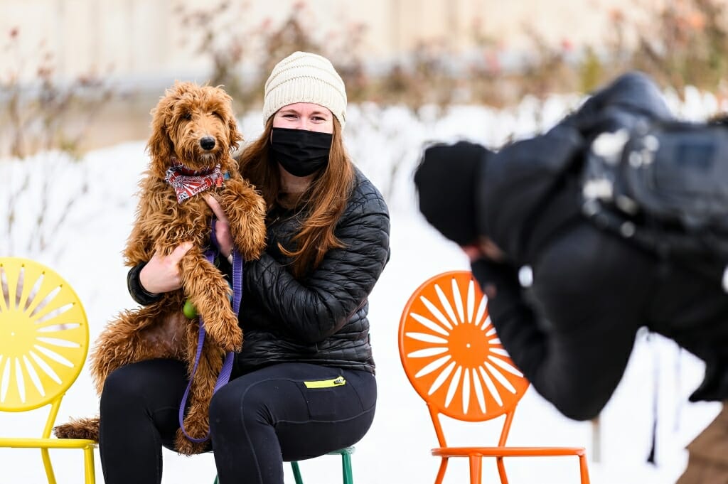 Lauren Sargeant and her six-month-old golden doodle Ellie pose for a photo with the Memorial Union Terrace’s iconic sunburst chairs.