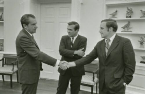 Nixon shaking hands with Cheney as Rumsfeld looks on