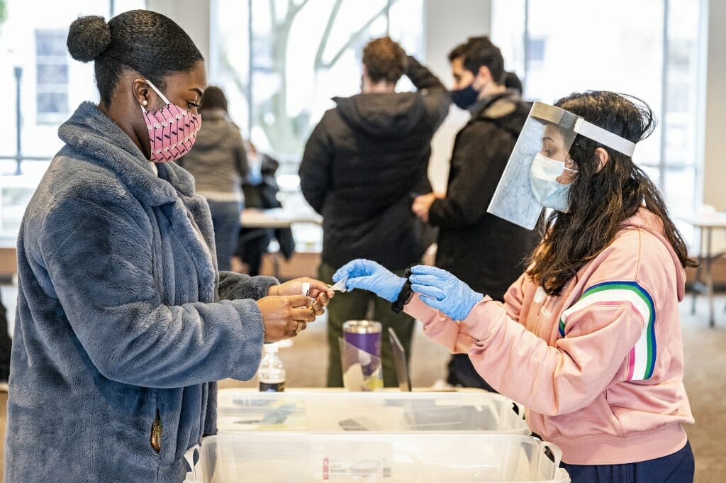 When arriving at the testing site, student Kingsley Pissang is given testing materials including a vial and a funnel.