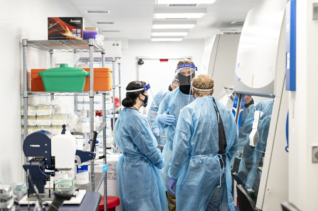 Workers process COVID-19 testing samples at the T3 Shield testing trailer located near the WARF Building. Test results are usually complete within 24 hours.