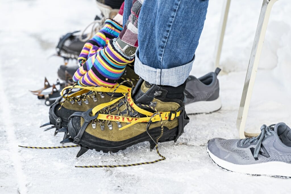 Participants lace up boots with crampons attached to get a good grip on ice.