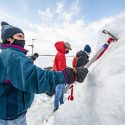 Student Hernan Ballard sinks an ice axe into the ice to get a handhold.