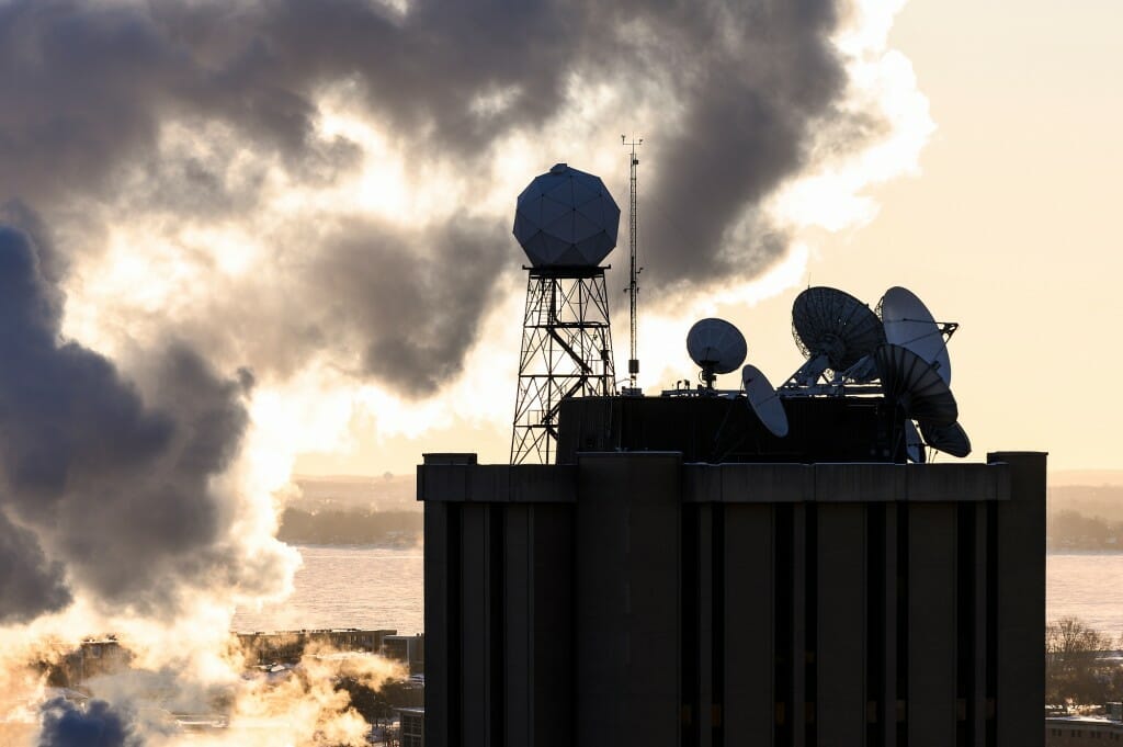 Satellite dishes and meteorological instruments atop the Atmospheric, Oceanic and Space Sciences Building are seen is silhouette during a frigid, subzero winter sunrise on Feb. 7.