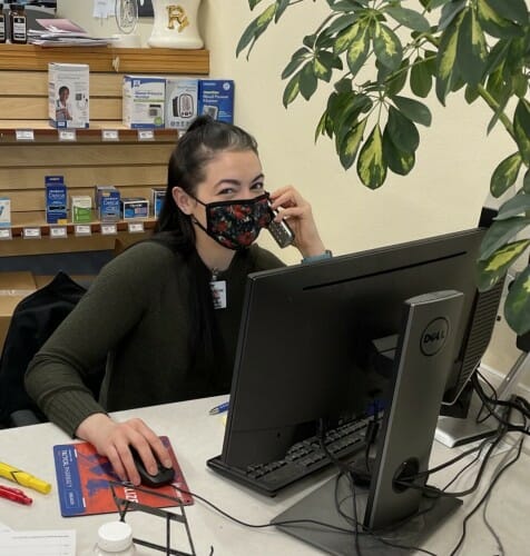 Person sitting at computer while talking on phone