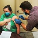 Person inserting needle into patient's arm