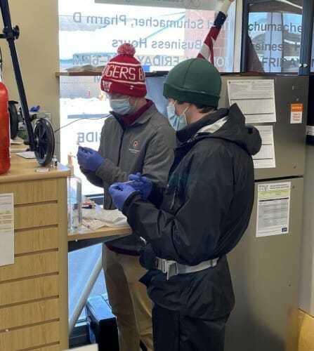 2 people standing at a counter holding syringes