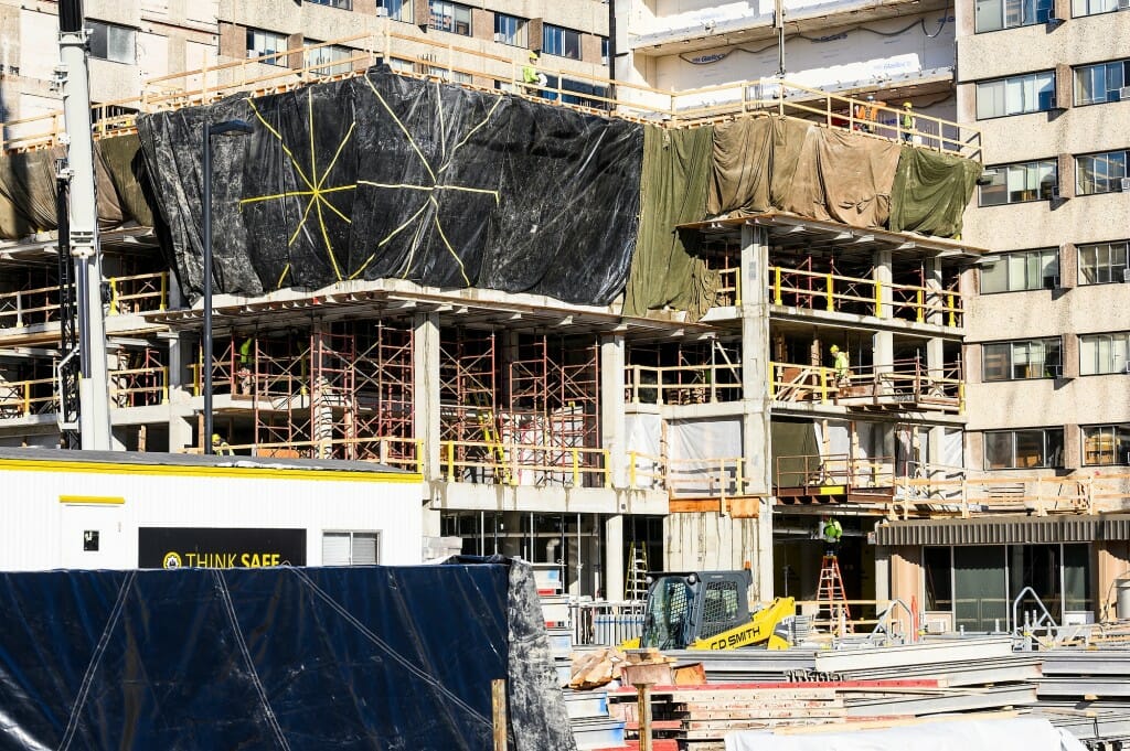 Cranes hoist and lower material for the building addition to Sellery Residence Hall.