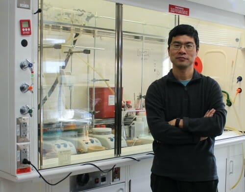 Portrait of Tang posing in his lab