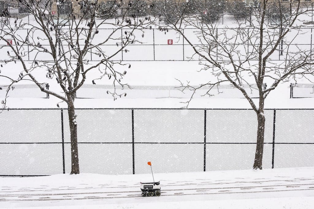 A University Housing food-delivery robot makes its way through the snow.