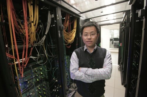 Yu posing between computer racks