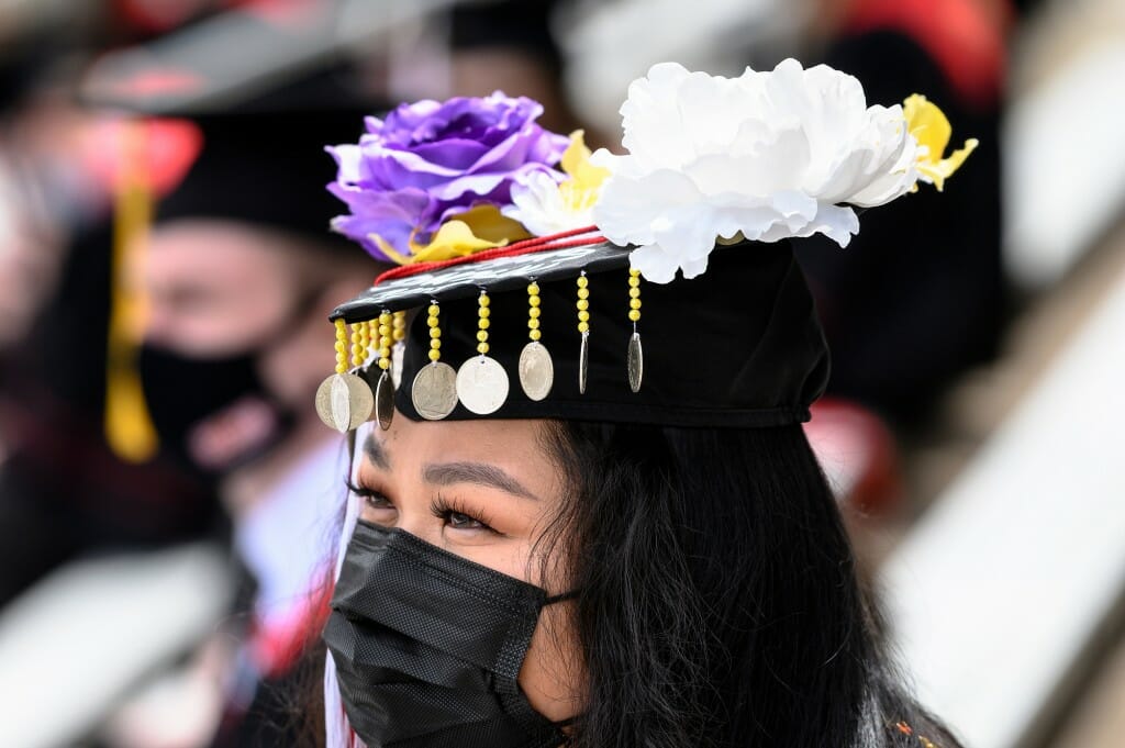 A mortarboard decorated with purple, white and yellow flowers as well as beadwork