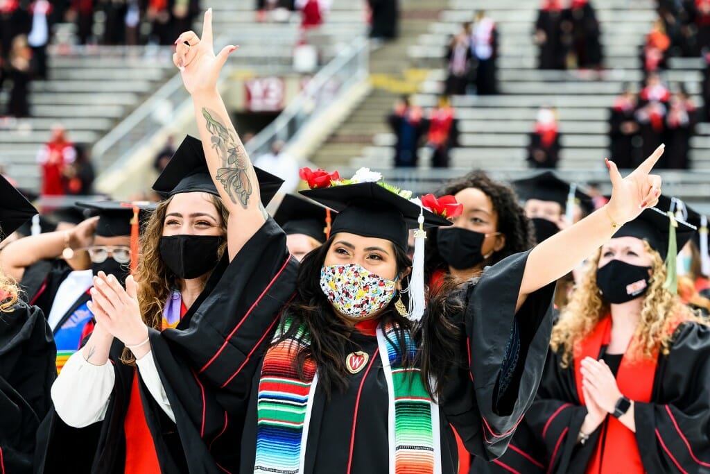 A graduate throws her arms wide