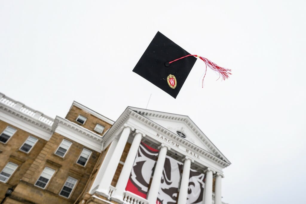 A cap and tassel being tossed in the air over Bascom Hall