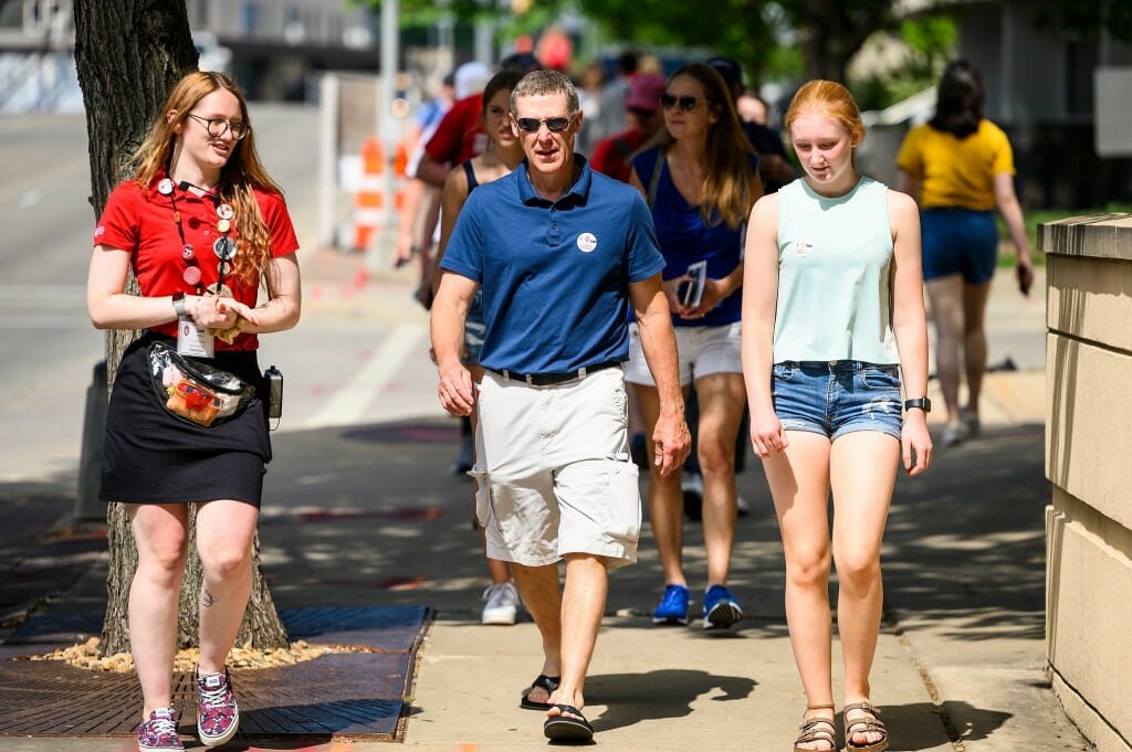 Guide and guests walking on sidewalk