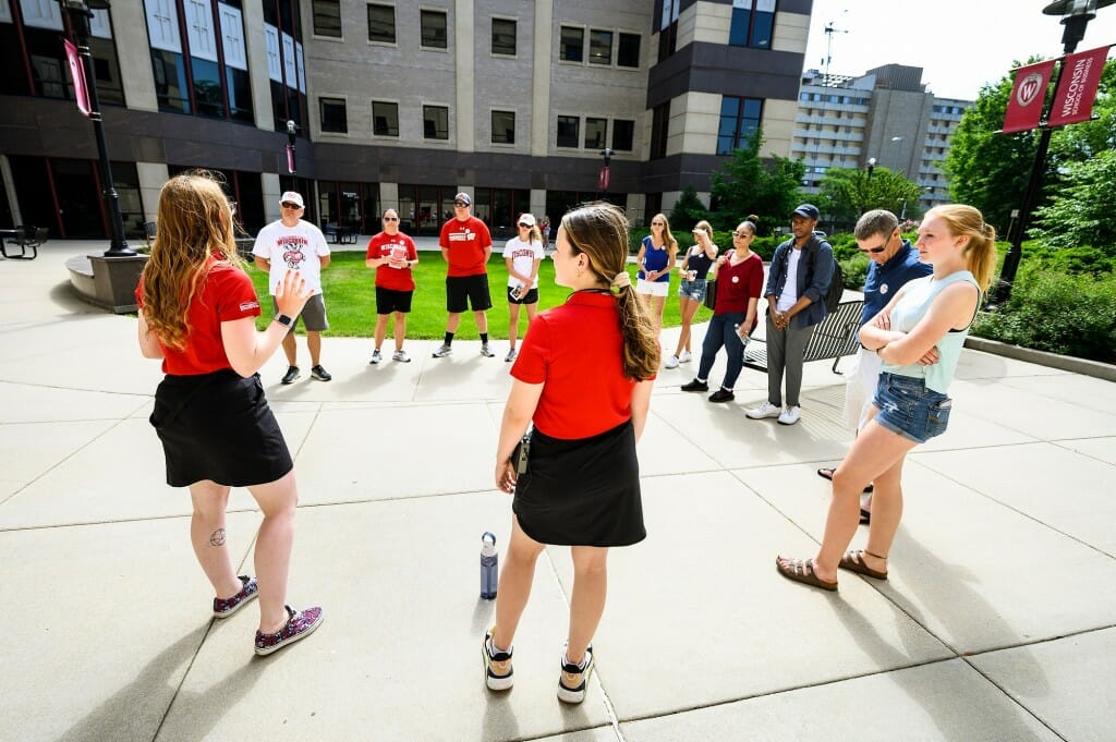 People standing in a circle on a paved plaza