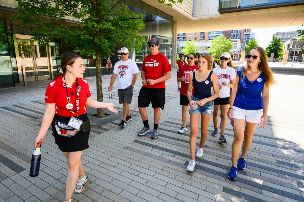 Guide walking on sidewalk while group follows