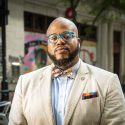 A photo of LaVar Charleston with State Street storefronts and murals in the background