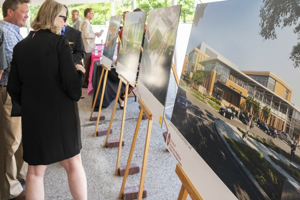 Attendees look over architectural renderings.