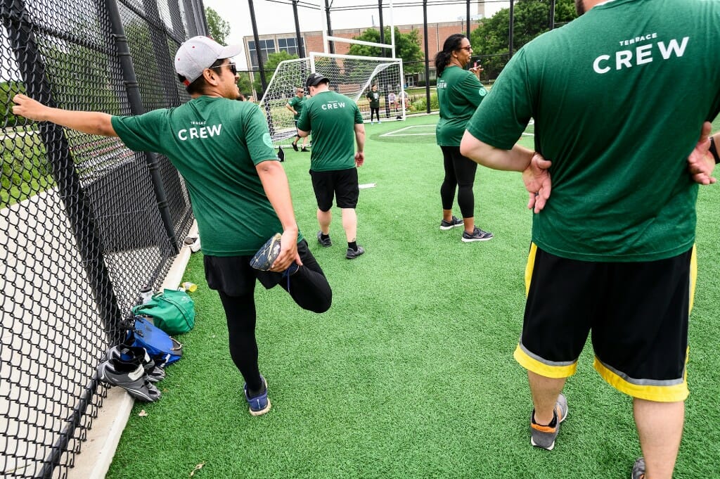 At left, Larry Jolon with the Wisconsin Union, warms up for kickball with some stretches.