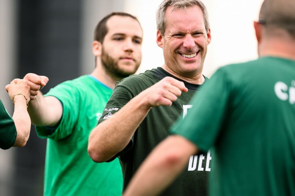 Playing as an honorary member of the Office of Human Resources (OHR) team, Jeff Novak, director of University Housing, fist bumps members of the Wisconsin Union after a hotly contested kickball game between the two employee teams.