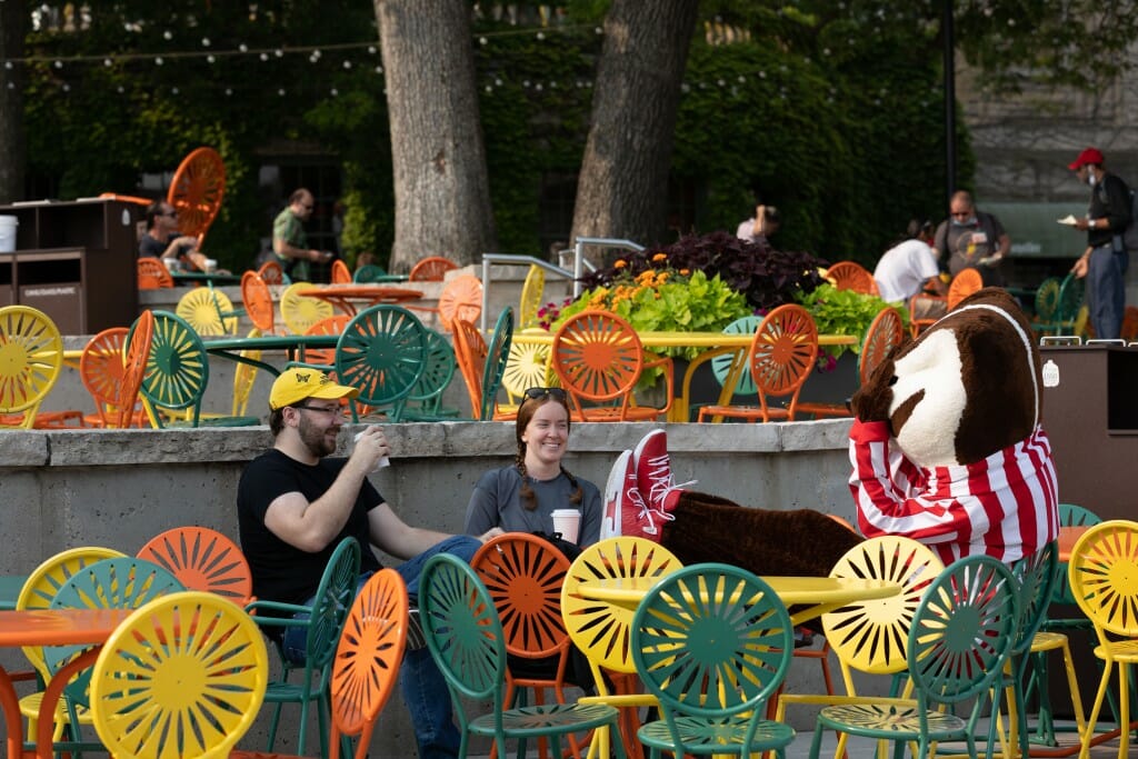 A view of people sitting on tables at the terrace.