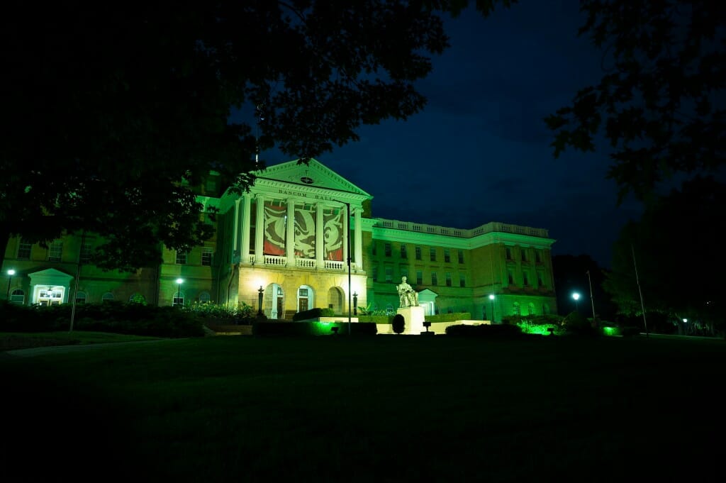 During a summer night on June 21, 2021, the University of Wisconsin-Madison illuminates the exterior of Bascom Hall and terrace plantings surrounding the Abraham Lincoln statue with green light in honor of the Milwaukee Bucks basketball team’s winning of the 2021 NBA Championship the evening before. Hanging between the Bascom Hall’s building columns is a graphic banner of UW-Madison mascot Bucky Badger. (Photo by Jeff Miller / UW-Madison)